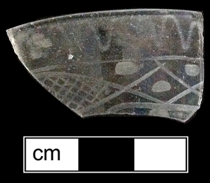 Colorless soda lime glass  tumbler or flip.  Wheel engraved below rim with wavy line and a row of hatched lozenges and dots. 3” rim diameter. Vessel 30 - Example on right from a private collection.  This motif was typical on drinking glasses produced by William Stiegel in Pennsylvania between 1763 and 1774 (McKearin and McKearin 1949).